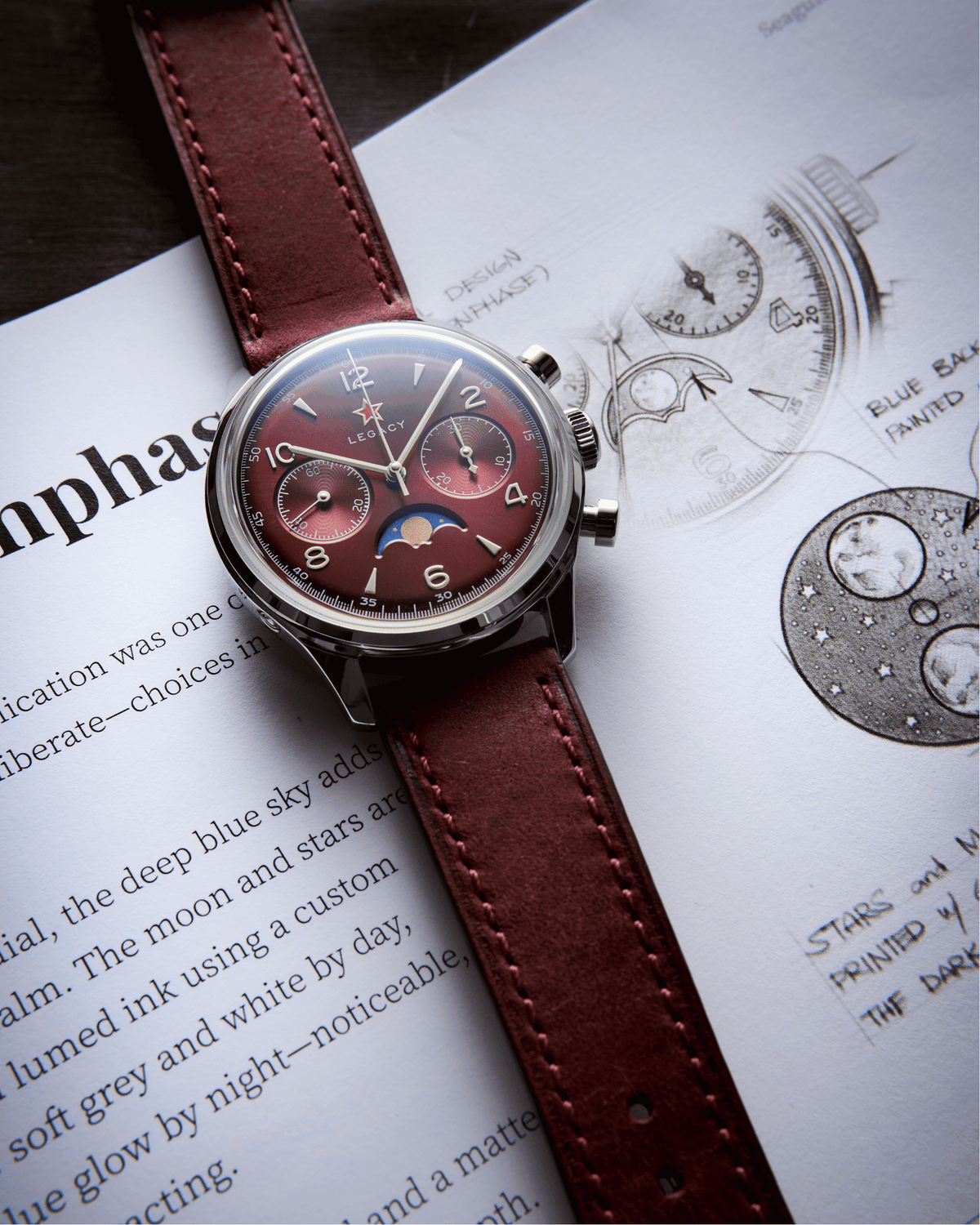 Seagull 1963 Legacy Burgundy on a wine-red strap resting on the archive page about the moonphase disc