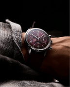 Seagull 1963 Legacy Burgundy on the wrist under a grey wool sleeve, dark burgundy leather strap