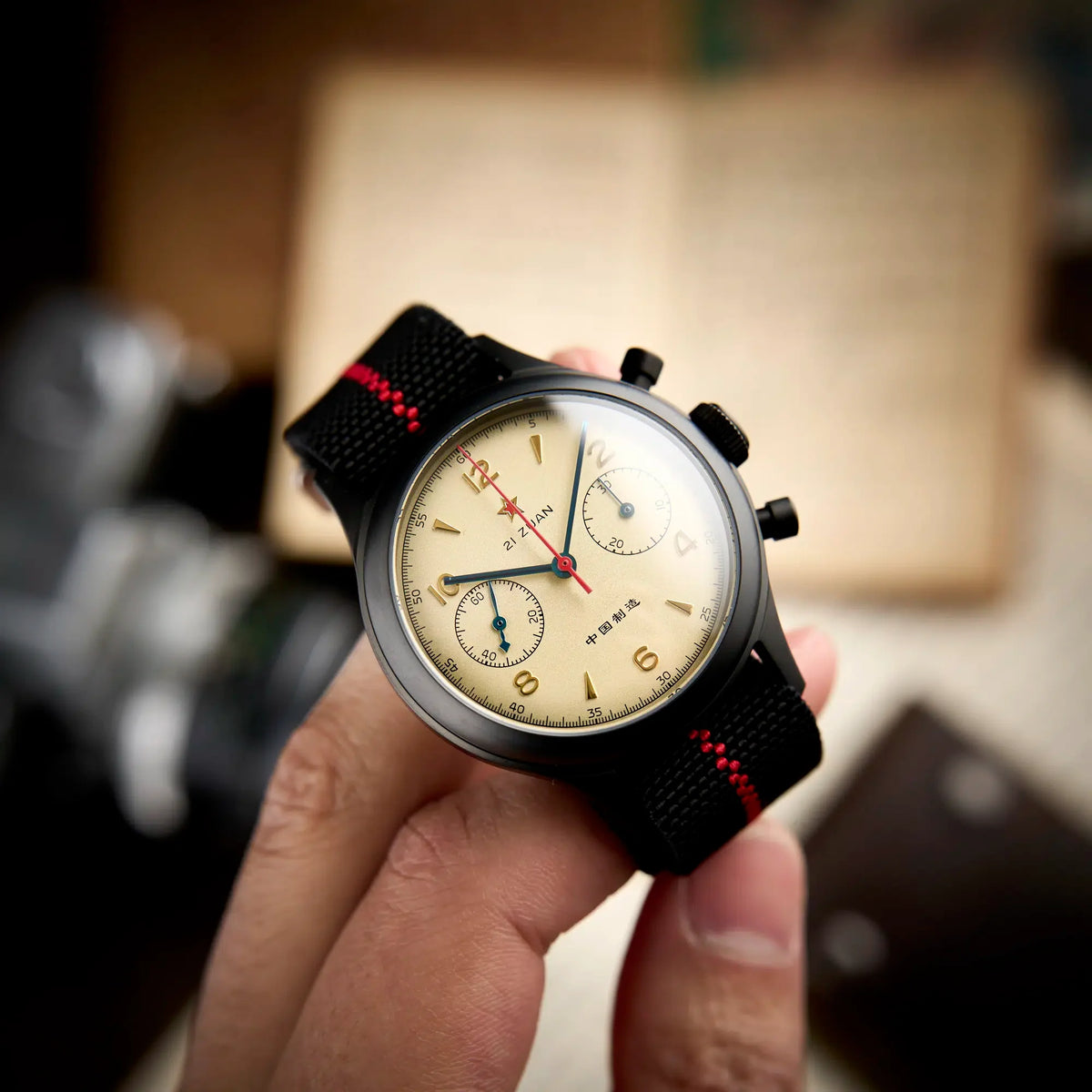 Seagull 1963 black case held in hand, cream dial close-up with the raised edge of the boxed sapphire crystal