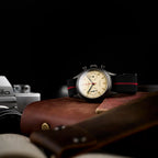 Seagull 1963 black-coated chronograph resting on a leather bag next to a film camera