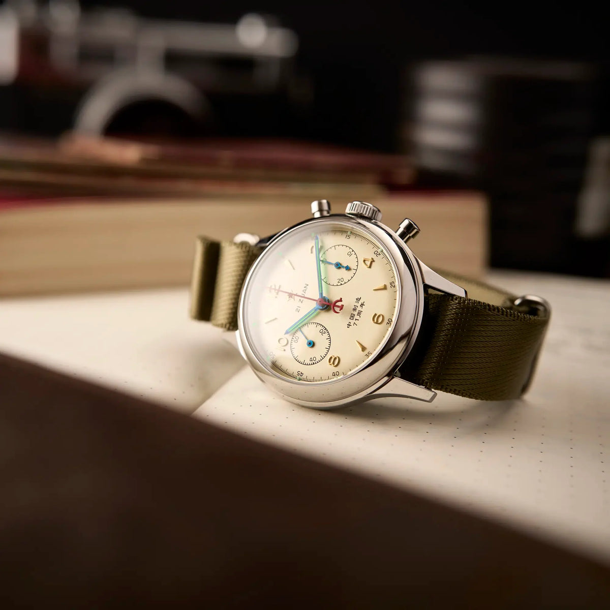 Seagull 1963 Lume 38mm at an angle on a notebook, domed crystal, knurled crown and pump pushers