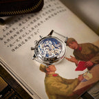 Seagull 1963 Moonphase Cream caseback face down on an illustrated Chinese book, strap removed