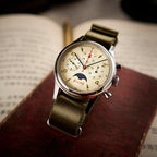 Seagull 1963 Moonphase Cream at an angle on a red book, gold numerals and the moon aperture in view