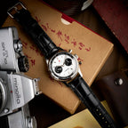 Seagull 1963 White Panda 40mm lying on a kraft box beside a vintage Minolta camera
