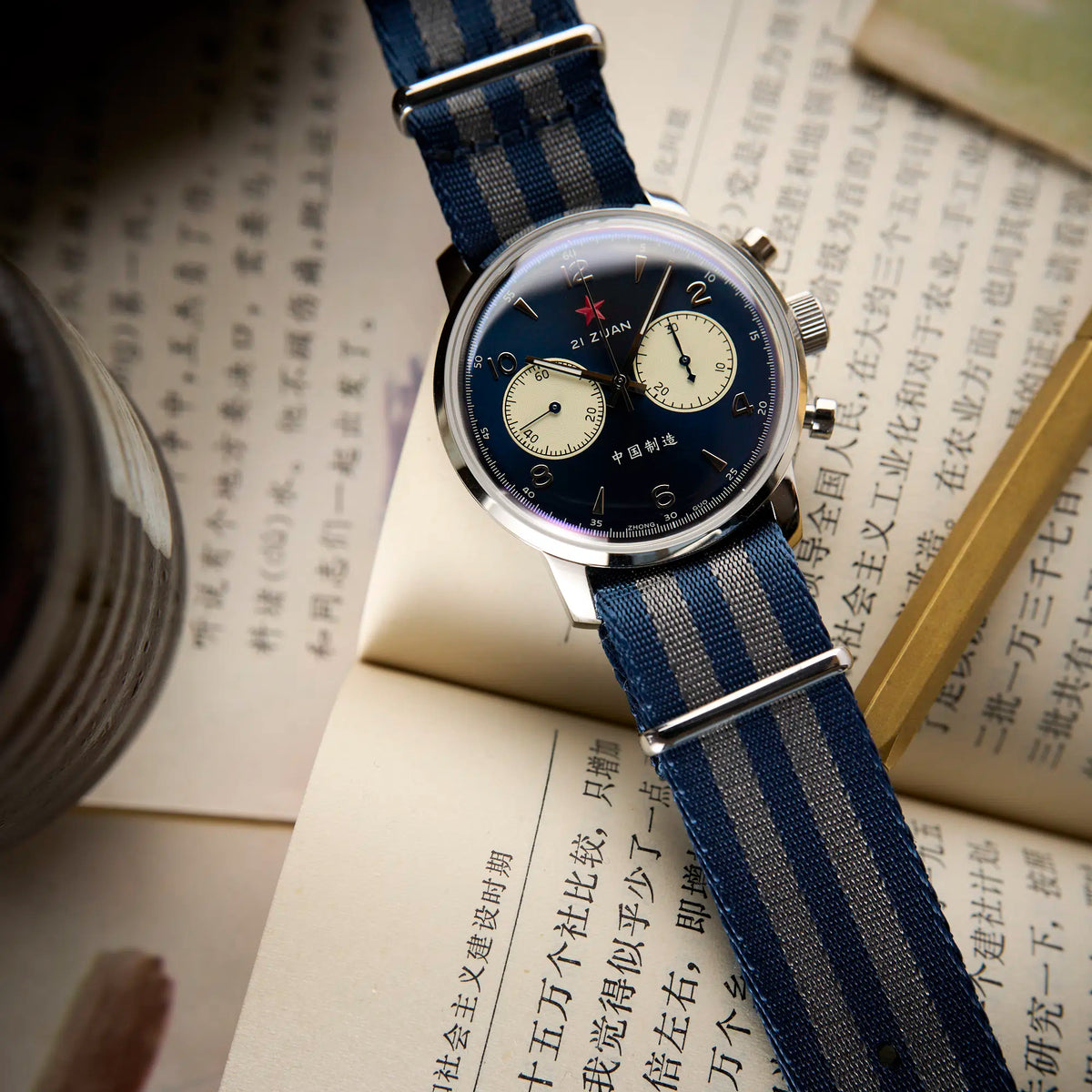 Seagull 1963 Blue Panda 42mm lying on an open Chinese book with a brass ruler beside it