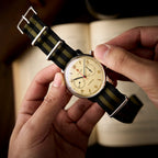 Seagull 1963 Air Force Cream 42mm held in both hands over an open book, dial angled to the light