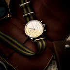 Seagull 1963 Air Force Cream 42mm lying in a brown leather travel case with sunglasses and a camera