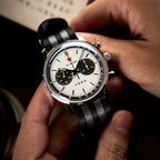 Seagull 1963 White Panda Sport 42mm cradled in two hands above a book printed in Chinese