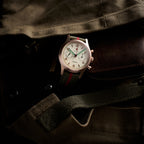 Seagull 1963 Bronze Lume 40mm lying on an olive canvas jacket with brown leather trim