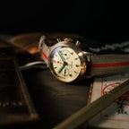 Seagull 1963 Bronze Lume resting on a leather pouch with papers, dark background, lumed hands