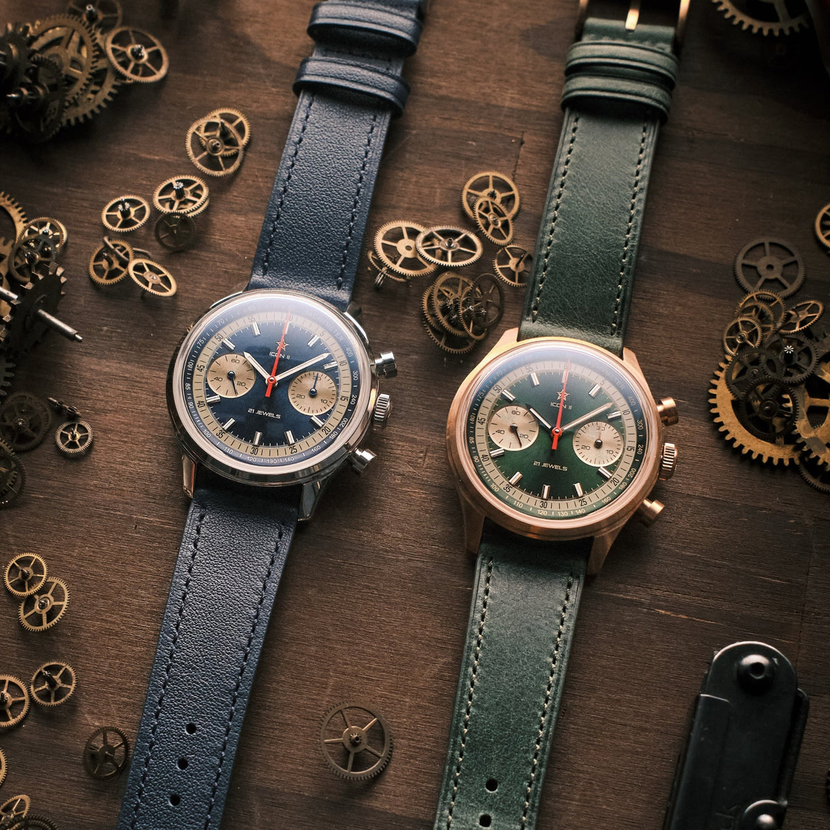 Seagull 1963 Icon II Blue beside the green bronze version on wood with loose watch parts