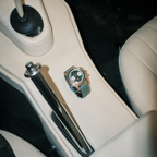 Seagull 1963 The Icon bronze lying on a cream leather car console beside the handbrake
